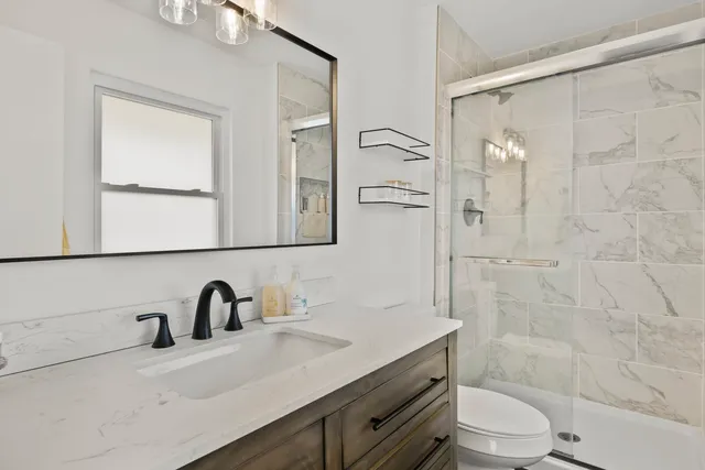 a bathroom with a sink a toilet and shower