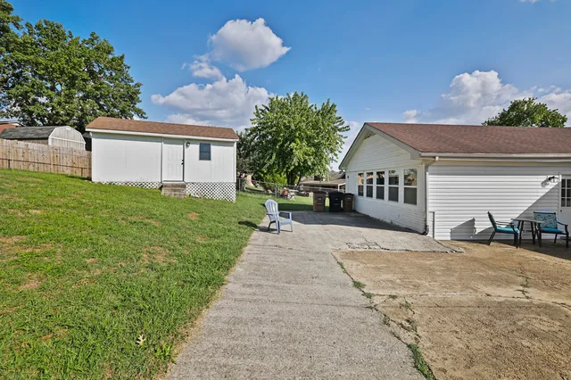 a view of a house with a yard and sitting area