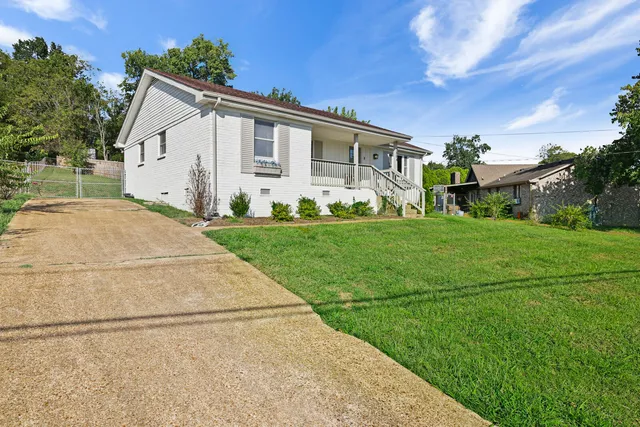 a view of a white house with yard