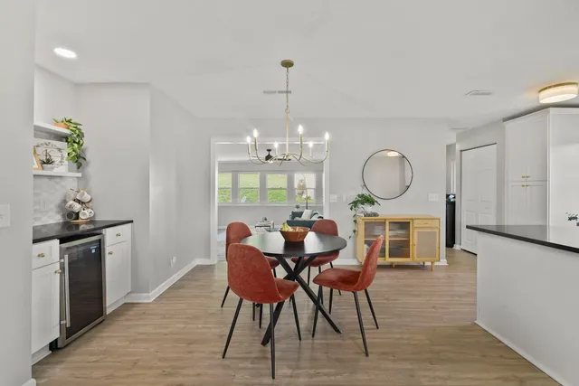 a view of a dining room with furniture a chandelier and wooden floor