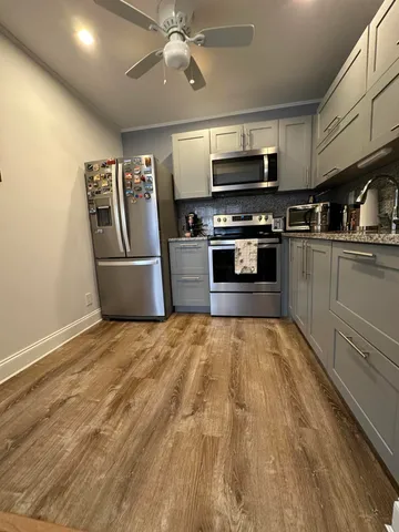 a kitchen with granite countertop a refrigerator and a stove top oven