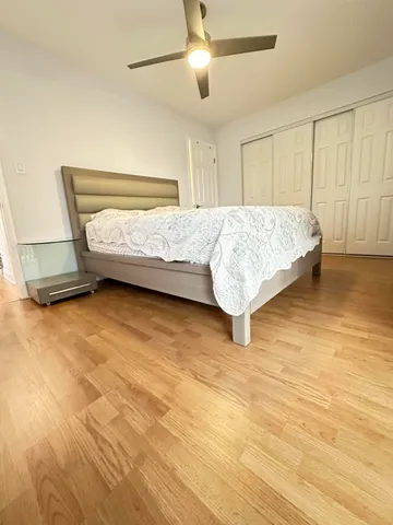 a bedroom with a bed and a ceiling fan
