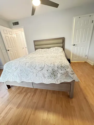 a bedroom with a bed and wooden floor