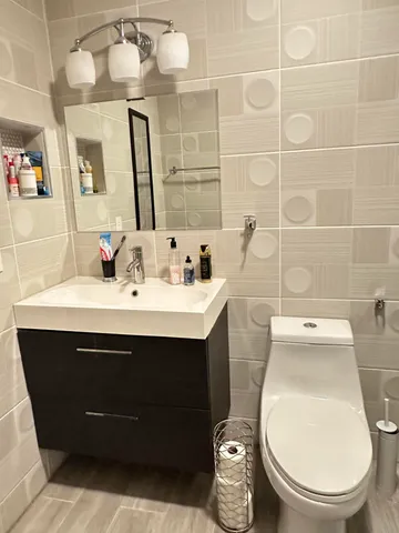 a bathroom with a sink mirror vanity and toilet