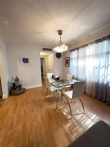 a view of a dining room with furniture a chandelier and wooden floor