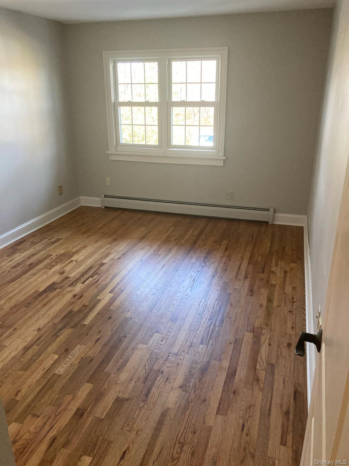2 Colonial Road, Unit 126 Beacon, NY 12508 - Photo 5 of 11 Unfurnished room with a baseboard heating unit and wood finished floors