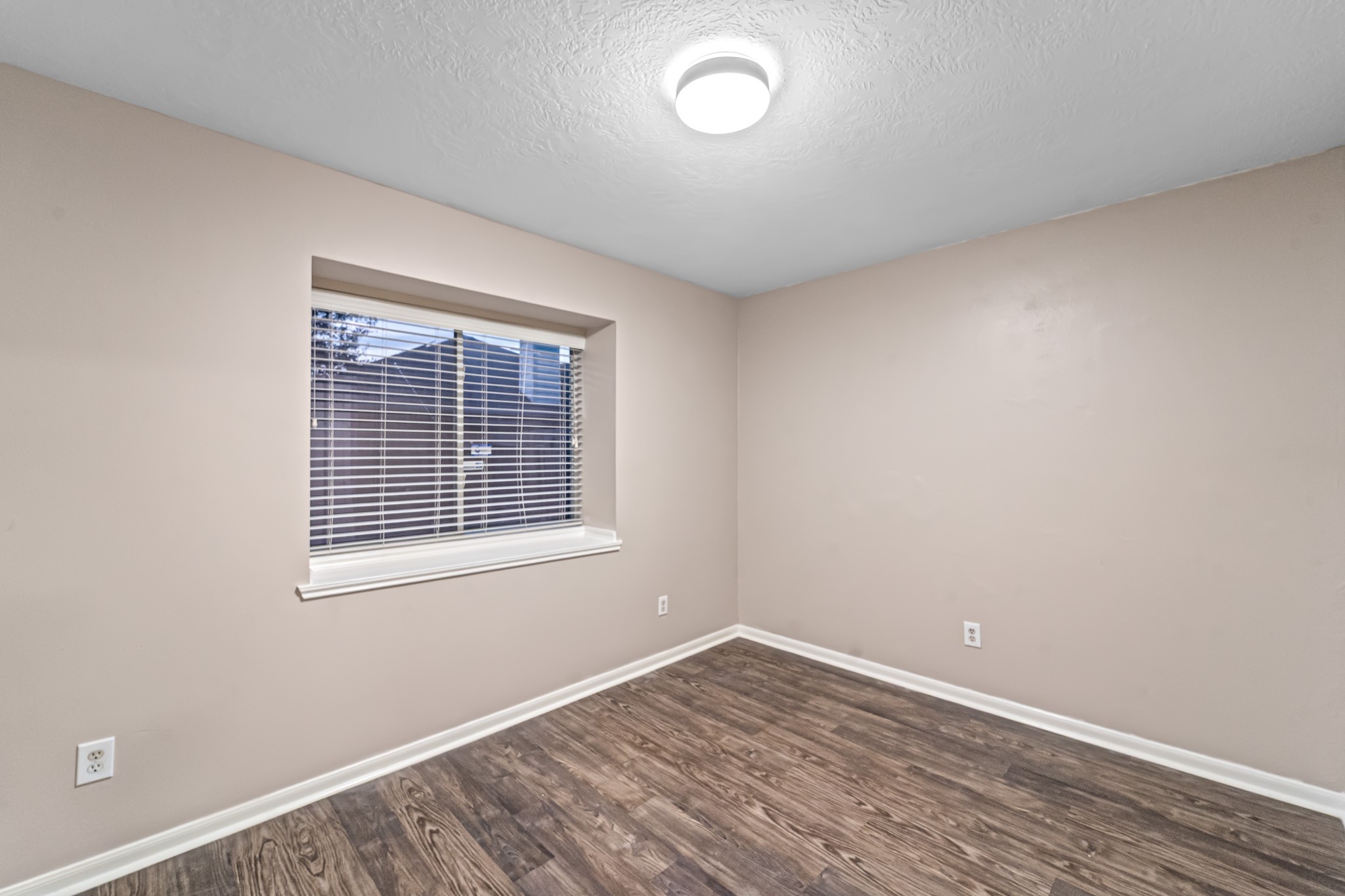 6827 Highwind Bend Lane Katy, TX 77449 - Photo 14 of 20 an empty room with wooden floor and windows