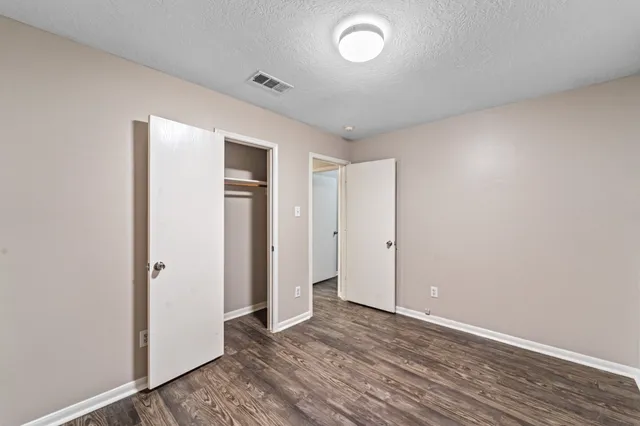 an empty room with wooden floor and closet