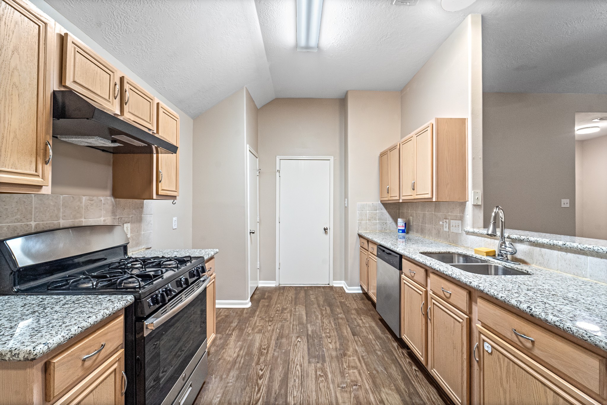 6827 Highwind Bend Lane Katy, TX 77449 - Photo 8 of 20 a kitchen with stainless steel appliances granite countertop a stove and a sink
