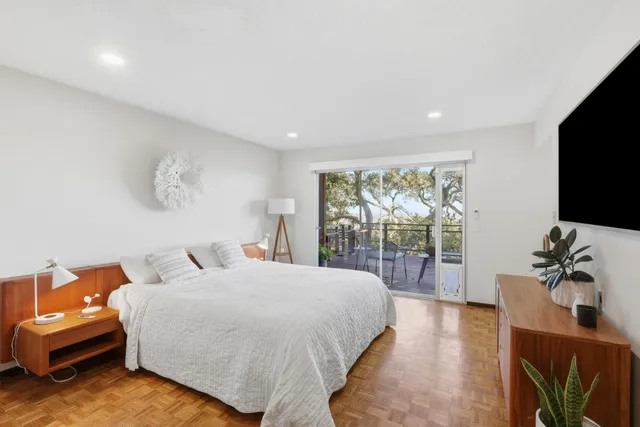 a bedroom with a bed and large flat screen tv