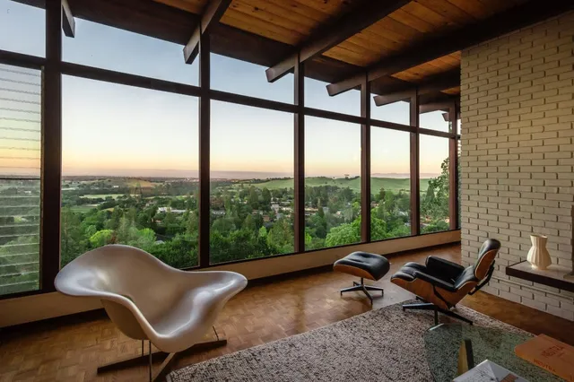 a living room with furniture and a floor to ceiling window