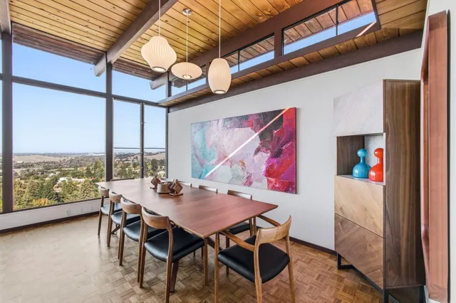 a dining room with furniture and a floor to ceiling window