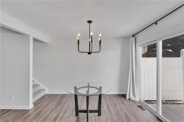 a view of a room with wooden floor lounge chair and windows