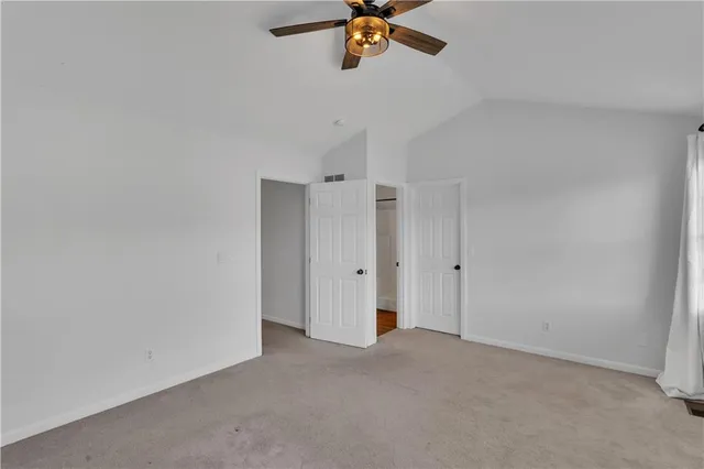 a view of a room with a ceiling fan and window