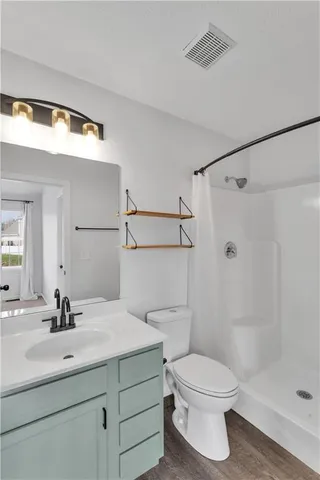a bathroom with a sink a toilet and shower