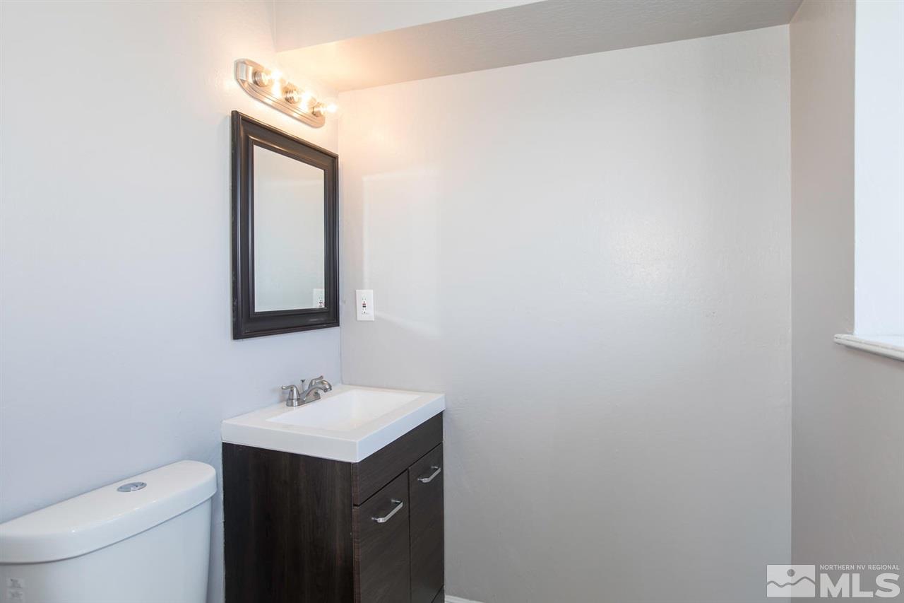 425 Hoge Road Reno, NV 89506 - Photo 17 of 25 a bathroom with a toilet a sink a mirror and vanity