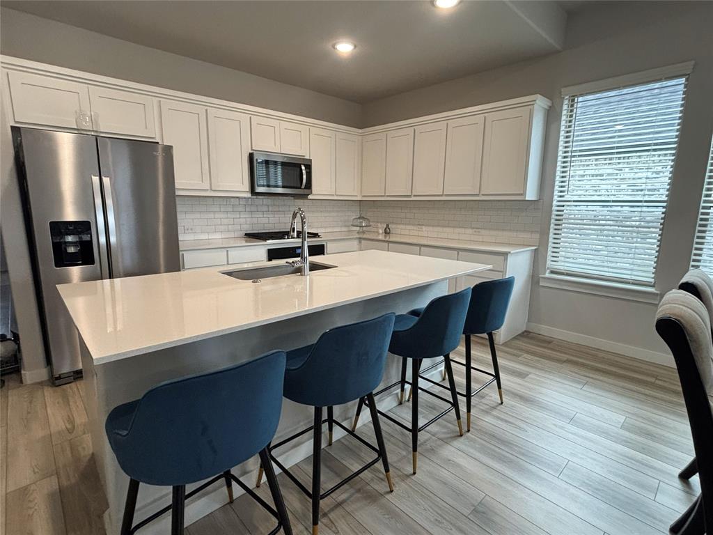 2029 Dovedale Drive Forney, TX 75126 - Photo 5 of 18 a kitchen with stainless steel appliances a table chairs microwave and refrigerator