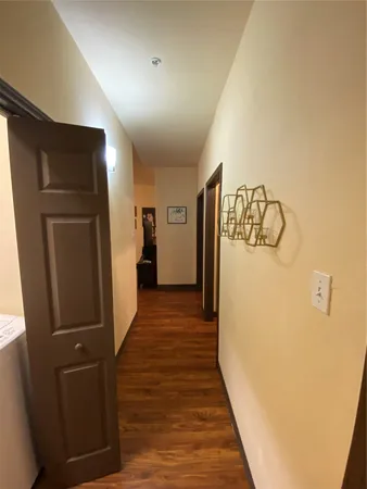 a view of a hallway with wooden floor