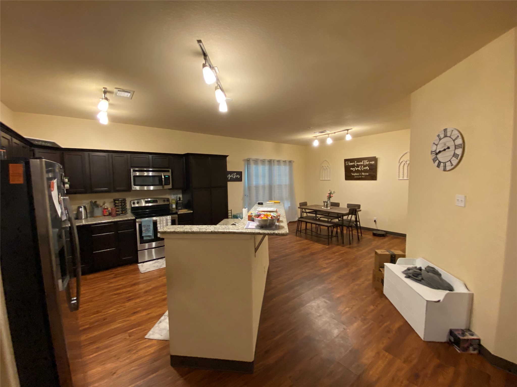1239 20th Street, Unit B Huntsville, TX 77340 - Photo 9 of 17 a living room with couches kitchen view and a refrigerator
