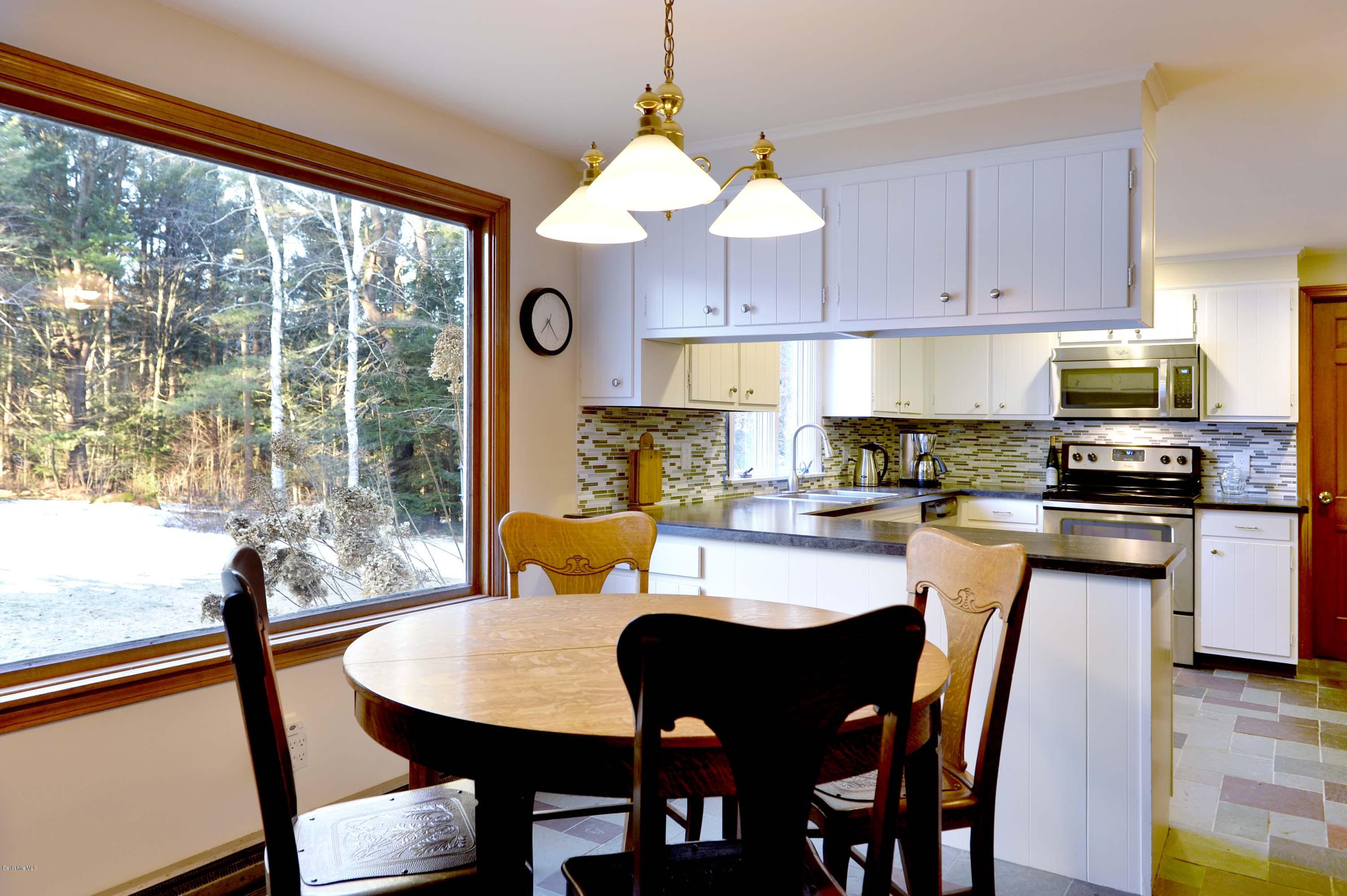 350 Lenox Road Richmond, MA 01254 - Photo 11 of 30 a kitchen with stainless steel appliances granite countertop a stove a refrigerator a kitchen island a table and chairs with wooden floor
