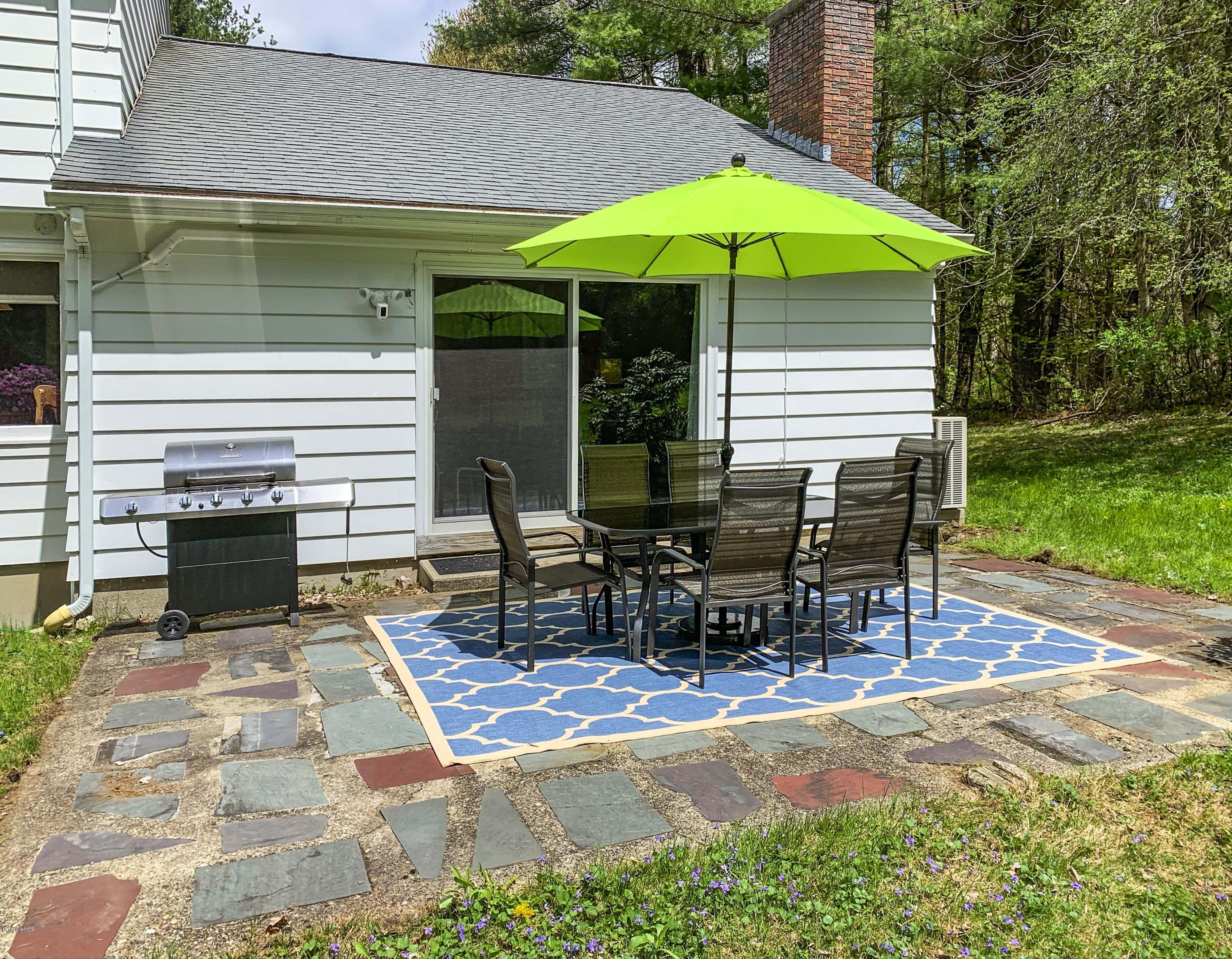 350 Lenox Road Richmond, MA 01254 - Photo 4 of 30 a view of a patio with a table and chairs under an umbrella