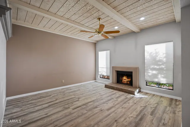 a view of an empty room with a fireplace and a window