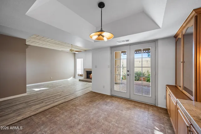 a view of an empty room with window and wooden floor