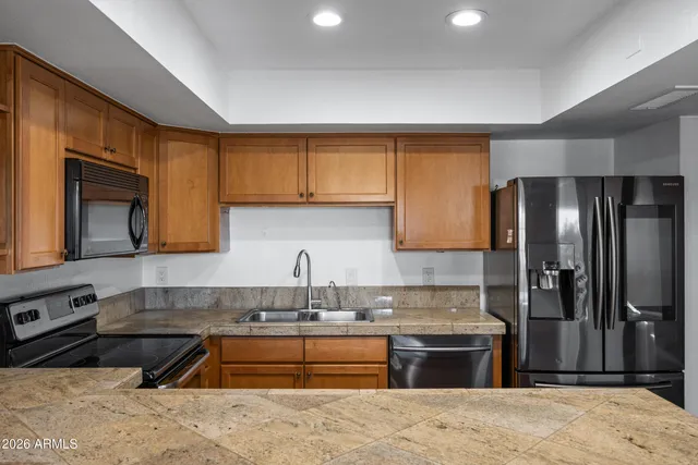a kitchen with stainless steel appliances granite countertop a sink stove and refrigerator
