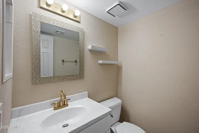 a bathroom with a sink mirror and toilet