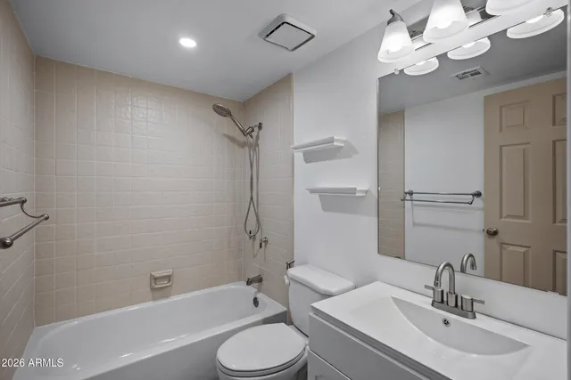 a bathroom with a toilet a sink a mirror a bathtub and shower