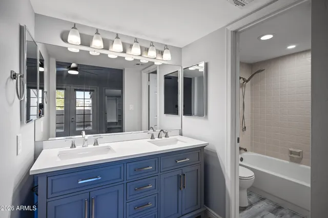 a bathroom with a sink double vanity granite tub and a large mirror