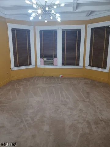a view of an empty room with window and stairs
