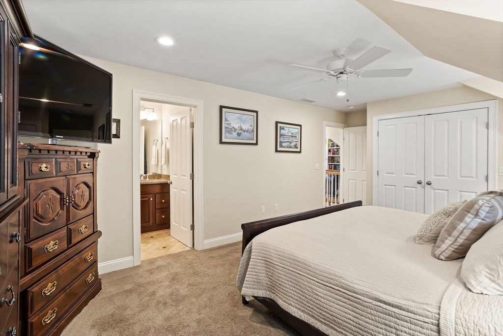 57 Sunset Ridge Lane, Unit 57 Bolton, MA 01740 - Photo 28 of 42 a bedroom with a bed and a flat screen tv