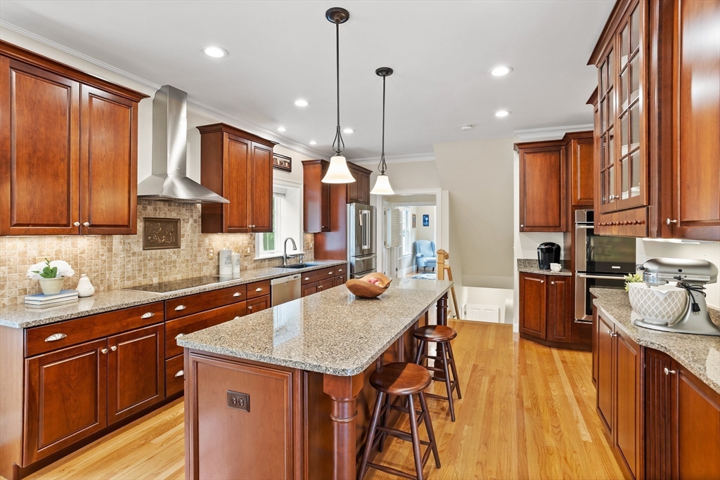 57 Sunset Ridge Lane, Unit 57 Bolton, MA 01740 - Photo 3 of 42 a kitchen with stainless steel appliances granite countertop a kitchen island a stove a sink a dining table and chairs