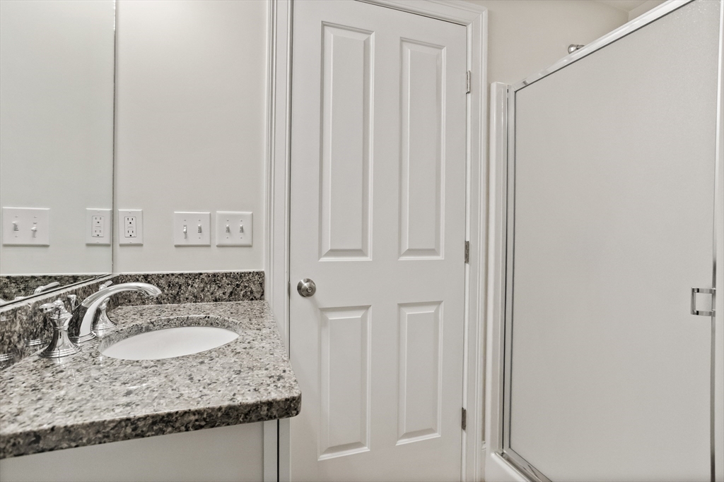 57 Sunset Ridge Lane, Unit 57 Bolton, MA 01740 - Photo 35 of 42 a bathroom with a granite countertop sink and a mirror