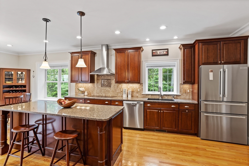 57 Sunset Ridge Lane, Unit 57 Bolton, MA 01740 - Photo 4 of 42 a kitchen with stainless steel appliances granite countertop a stove a sink dishwasher a refrigerator with a dining table and chairs