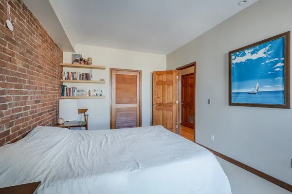 a bedroom with a bed and a painting on the wall