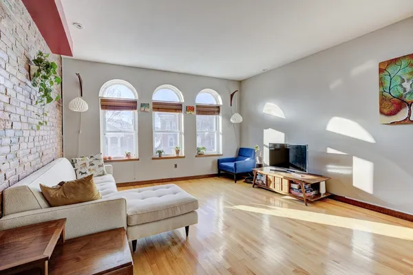 a living room with furniture flat screen tv and a large window