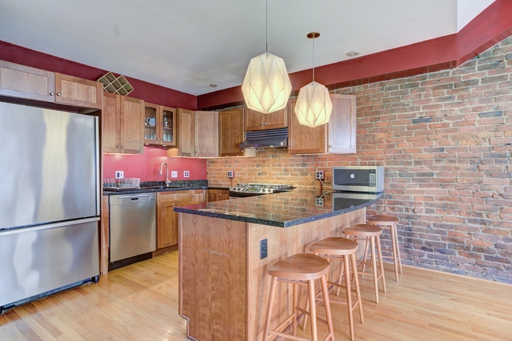 231 Main Street, Unit 3R Northampton, MA 01060 - Photo 6 of 22 a kitchen with stainless steel appliances granite countertop a sink a stove and refrigerator
