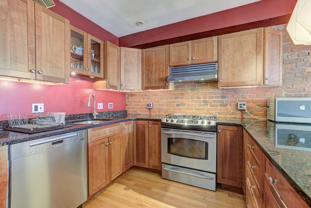 231 Main Street, Unit 3R Northampton, MA 01060 - Photo 8 of 22 a kitchen with granite countertop a sink stove and cabinets
