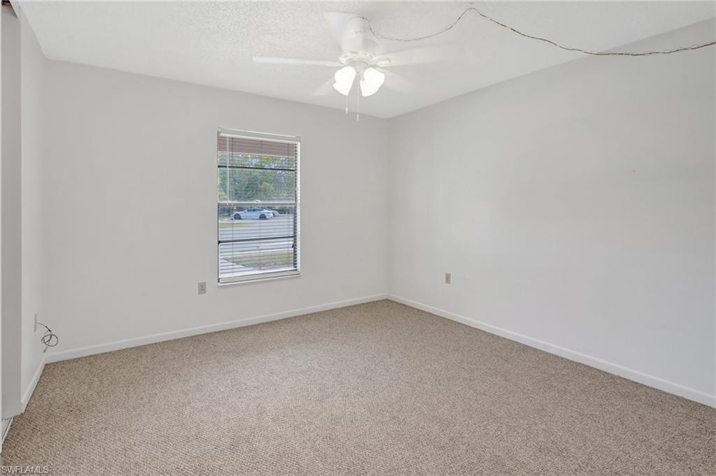 151 Cypress Way East, Unit D3 Naples, FL 34110 - Photo 12 of 46 Empty room featuring light carpet, baseboards, and a ceiling fan