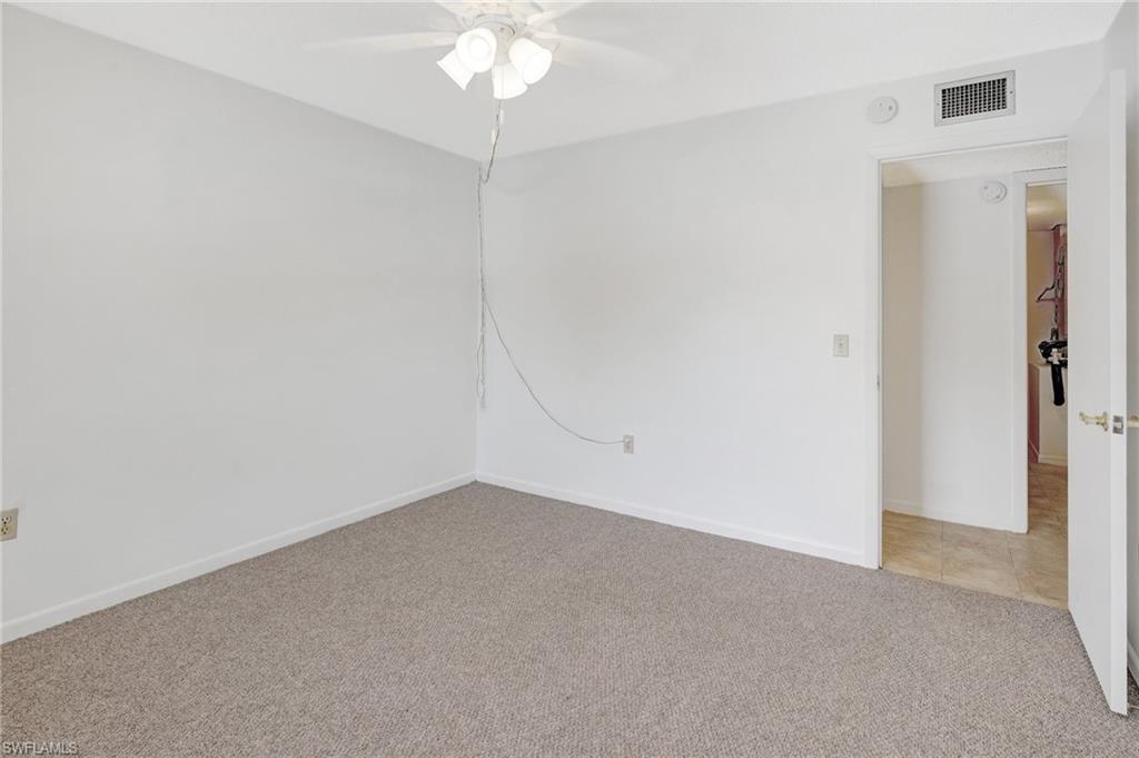 151 Cypress Way East, Unit D3 Naples, FL 34110 - Photo 13 of 46 Empty room featuring baseboards, light tile patterned floors, light colored carpet, visible vents, and ceiling fan