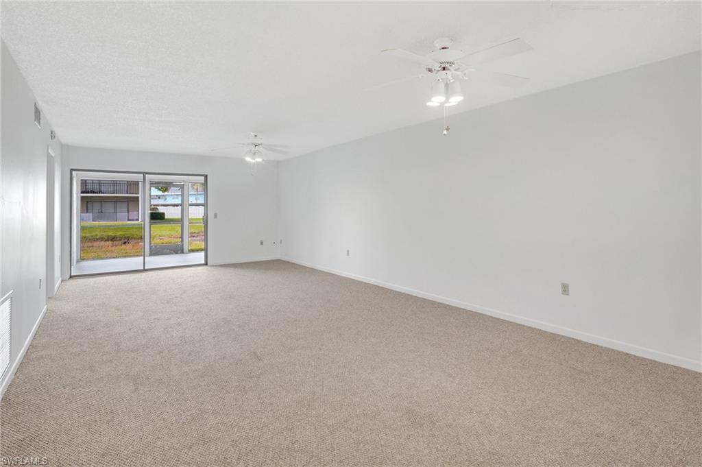 151 Cypress Way East, Unit D3 Naples, FL 34110 - Photo 16 of 46 Spare room featuring baseboards, ceiling fan, and light colored carpet