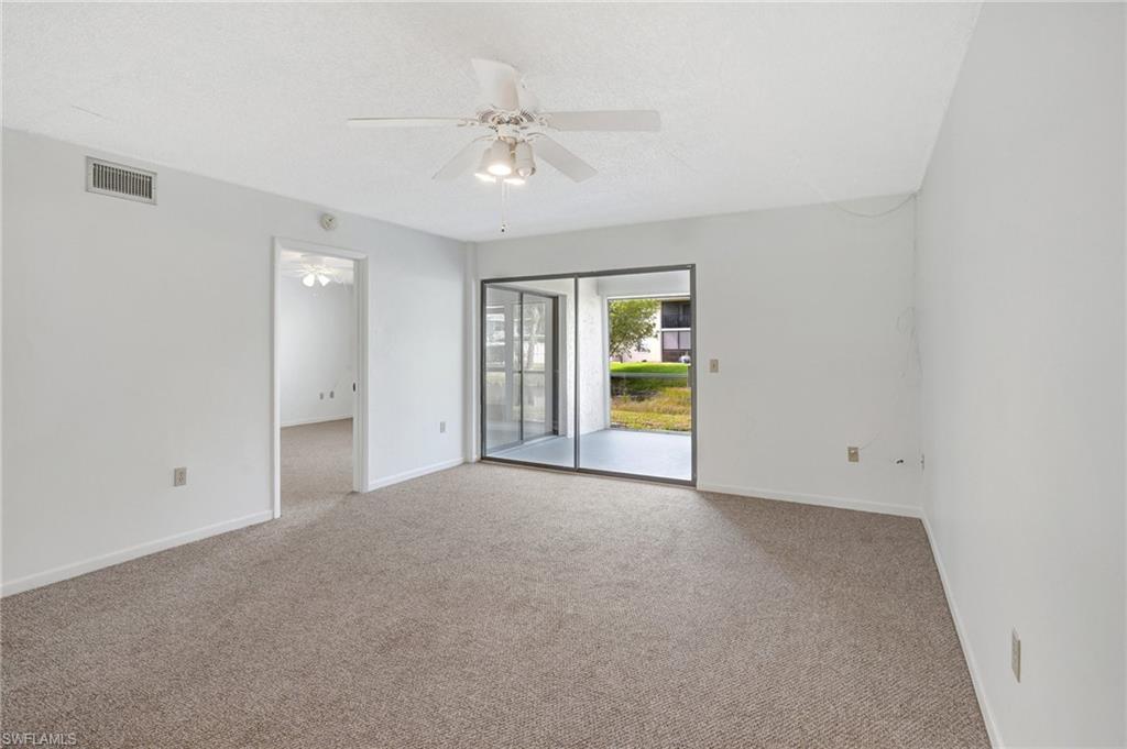 151 Cypress Way East, Unit D3 Naples, FL 34110 - Photo 19 of 46 Empty room with baseboards, a textured ceiling, carpet floors, ceiling fan, and visible vents