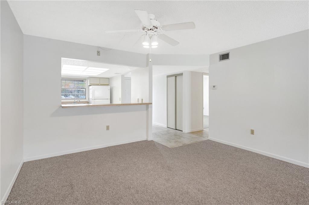 151 Cypress Way East, Unit D3 Naples, FL 34110 - Photo 20 of 46 Unfurnished room with light carpet, baseboards, visible vents, and ceiling fan