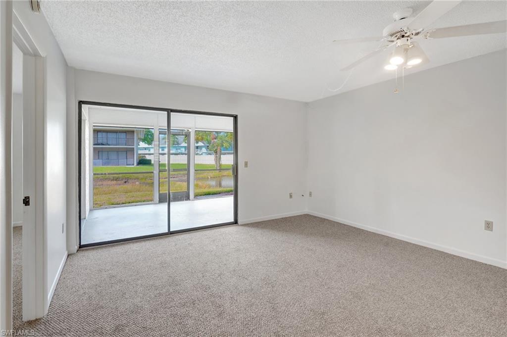 151 Cypress Way East, Unit D3 Naples, FL 34110 - Photo 21 of 46 Spare room with a textured ceiling, carpet flooring, ceiling fan, and baseboards