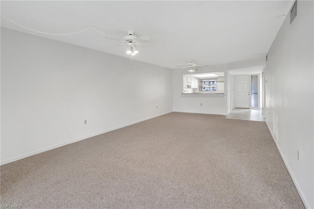 151 Cypress Way East, Unit D3 Naples, FL 34110 - Photo 22 of 46 Unfurnished room with light colored carpet, visible vents, baseboards, and a ceiling fan