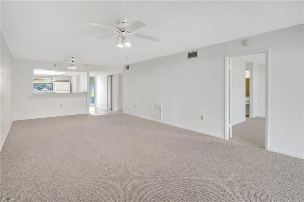 151 Cypress Way East, Unit D3 Naples, FL 34110 - Photo 23 of 46 Unfurnished living room with baseboards, visible vents, a ceiling fan, and light colored carpet