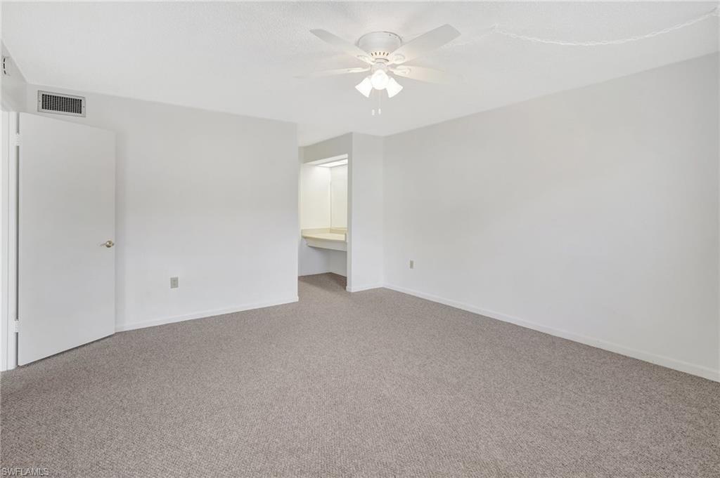 151 Cypress Way East, Unit D3 Naples, FL 34110 - Photo 25 of 46 Unfurnished room featuring baseboards, a ceiling fan, visible vents, and carpet