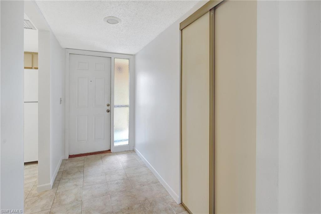 151 Cypress Way East, Unit D3 Naples, FL 34110 - Photo 34 of 46 Foyer entrance featuring baseboards and a textured ceiling